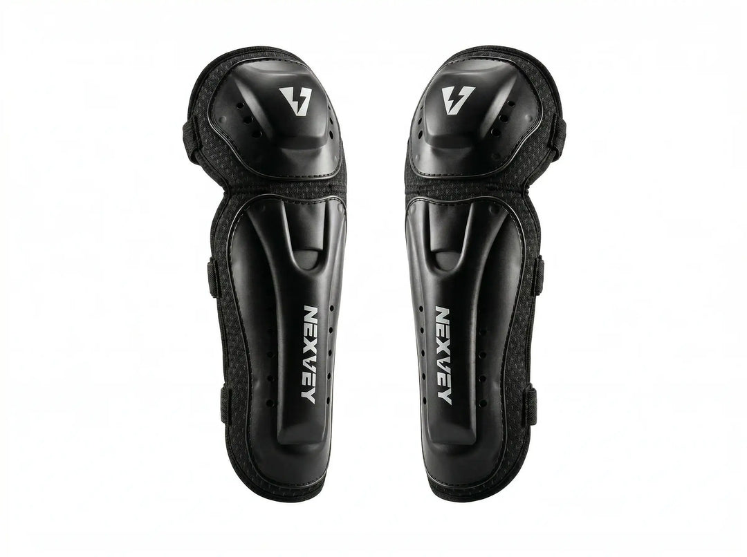 A pair of professional black NEXVEY motocross knee and shin guards featuring a durable hard shell design with the silver NEXVEY logo for youth racing protection