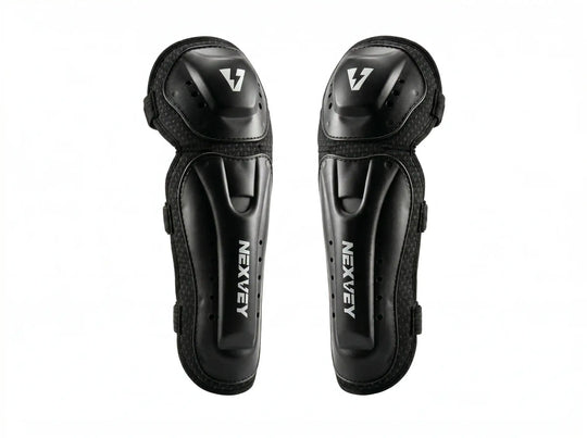 A pair of professional black NEXVEY motocross knee and shin guards featuring a durable hard shell design with the silver NEXVEY logo for youth racing protection