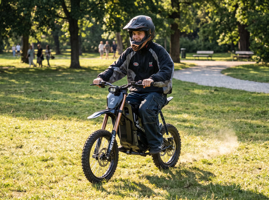 A helmeted rider on a black NEXVEY FLASH 2 electric dirt bike on park grass