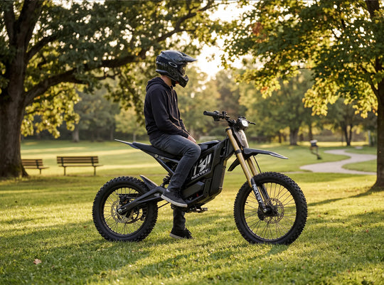 A teenage boy in a black hoodie and helmet relaxes while sitting on his Nexvey Flash Pro electric motorcycle on the green grass of a park at sunset, showcasing suburban youth lifestyle.
