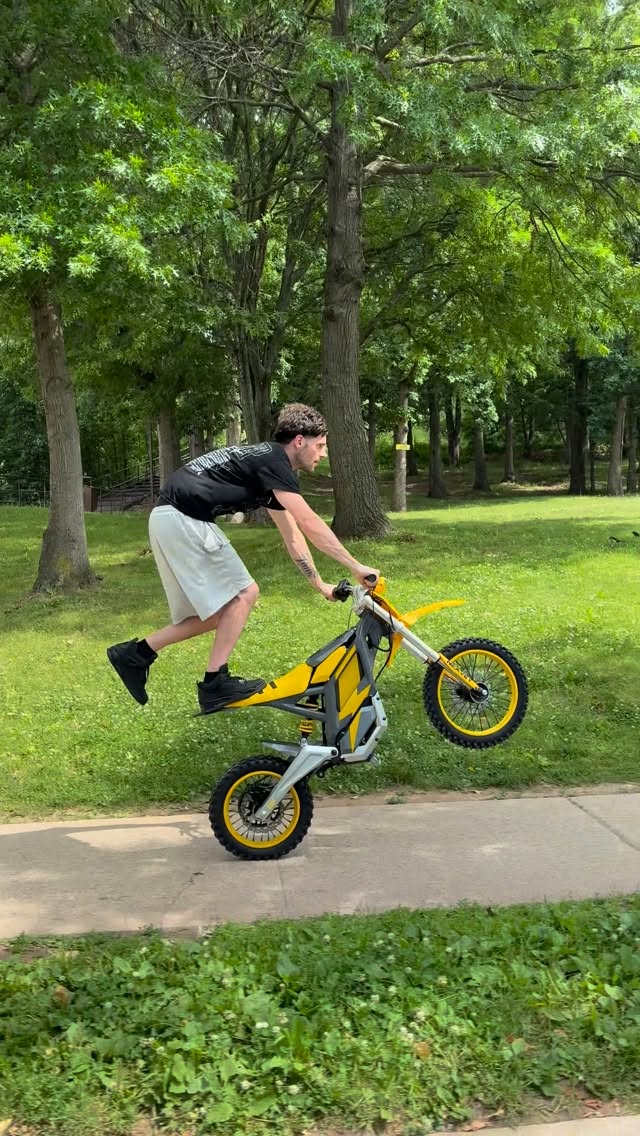 Yellow NEXVEY Flash electric dirt bike doing a wheelie