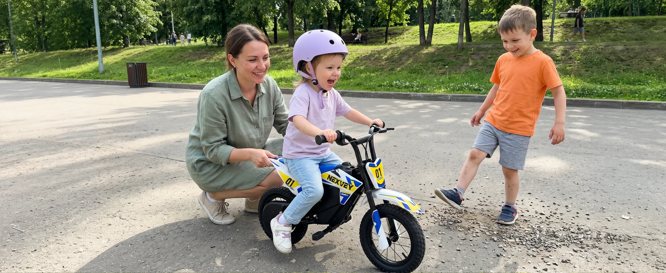 Young child riding a NEXVEY Spark 01 electric dirt bike with a parent outdoors