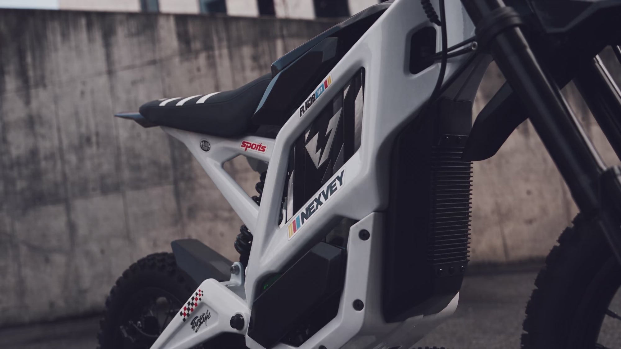 Three riders on NEXVEY electric dirt bikes perform wheelies and ride through urban spaces and a skatepark.