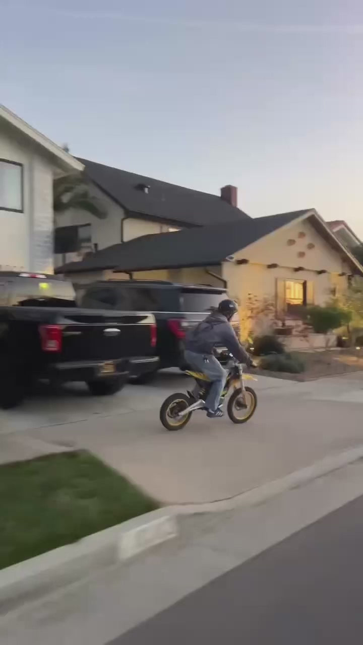 Colin Sloan performing street stunts on a Nexvey electric motorcycle in a U.S. neighborhood.