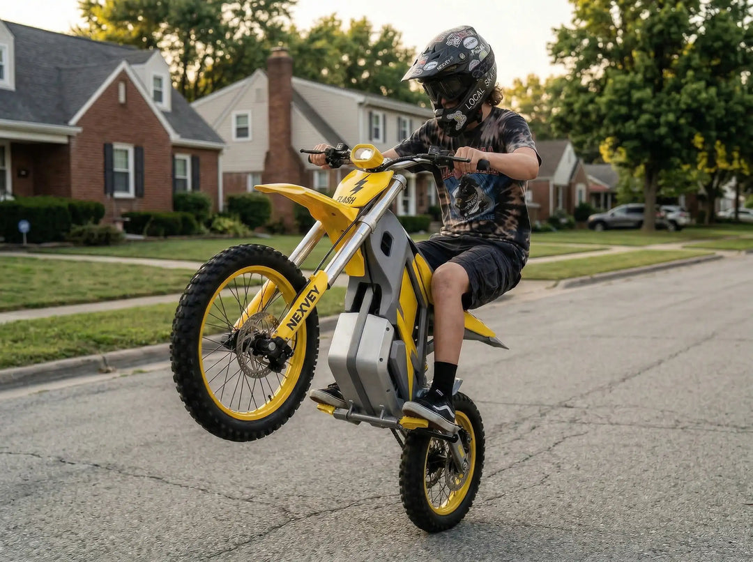 A teenager wearing a graphic tee and professional helmet performing a balanced wheelie stunt on a yellow NEXVEY FLASH electric dirt bike in a suburban neighborhood