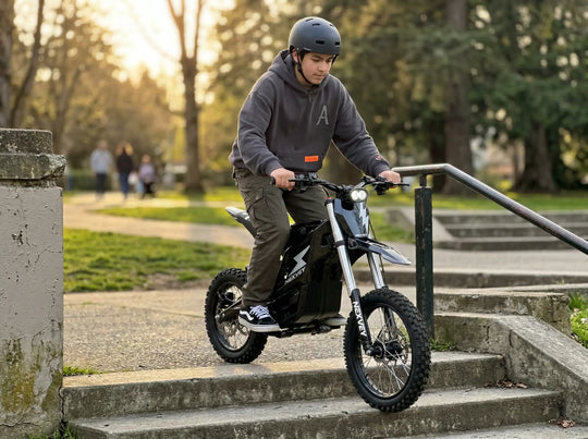 A teenager on a black NEXVEY FLASH electric dirt bike carefully navigating a descent down concrete park stairs, illuminated by a warm sunset glow