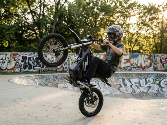 A rider wearing a graffiti-style helmet performing a vertical wheelie on a black NEXVEY FLASH electric dirt bike in a skate park with graffiti walls