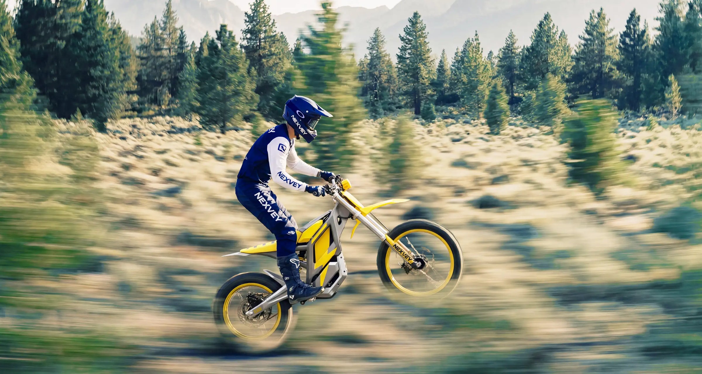 Youth rider on a Nexvey yellow and blue electric dirt bike performing a jump in the forest, high-performance teen motocross bike for off-road adventure