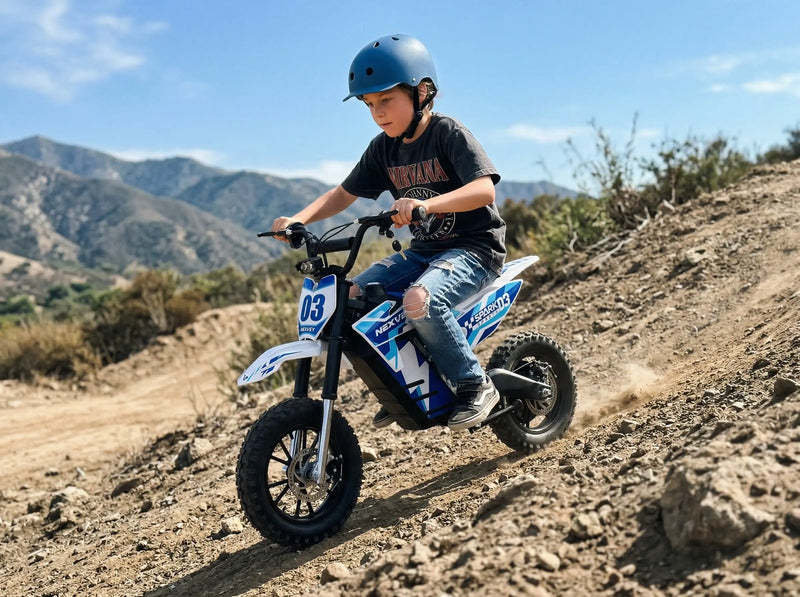 Young boy wearing a safety helmet riding a NEXVEY Spark D3 blue electric dirt bike on an off-road mountain trail.