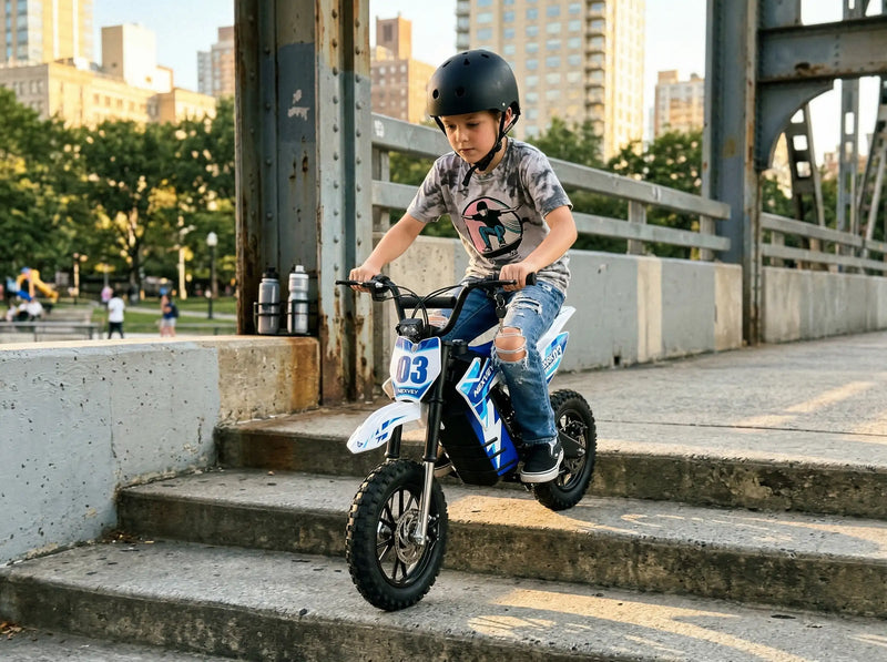 A young boy riding a blue NEXVEY Spark D3 electric dirt bike down concrete stairs in an urban city park setting