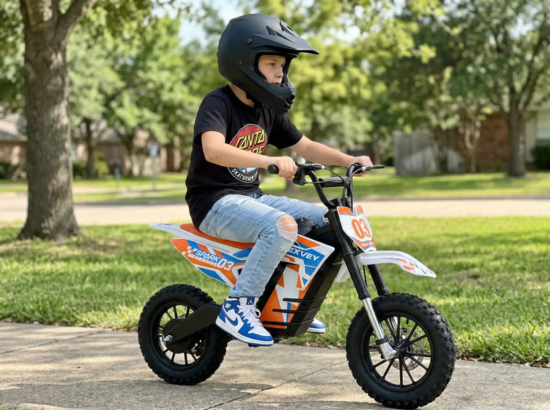 A teenage rider standing with two NEXVEY FLASH electric dirt bikes in black and yellow versions, holding a graffiti motocross helmet in a sunny outdoor trail setting