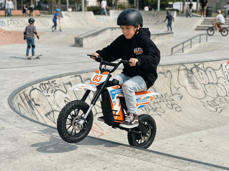 A teenage boy riding a white and orange NEXVEY SPARK 03 electric dirt bike through a sunny forest trail, showcasing its off-road performance for young riders